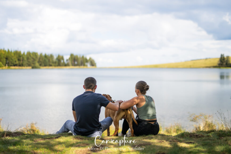 Un couple avec leur chien au bord du lac de Servières en Auvergne, capturé par Adrien Dupic, photographe animalier.